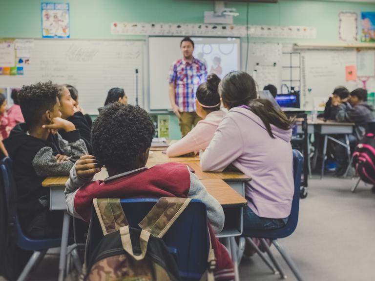 Schüler sitzen in einem Klassenzimmer beim Unterricht.