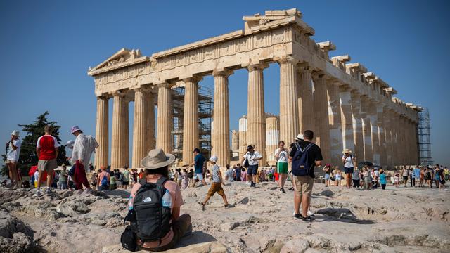Menschen stehen und sitzen vor einem Tempel in der Stadt Athen. 
