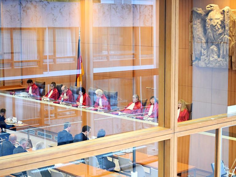 Blick durch eine Spiegelscheibe in den Gerichtssaal: Das Bundesverfassungsgericht verkündet das Urteil zum Nachtragshaushalt.