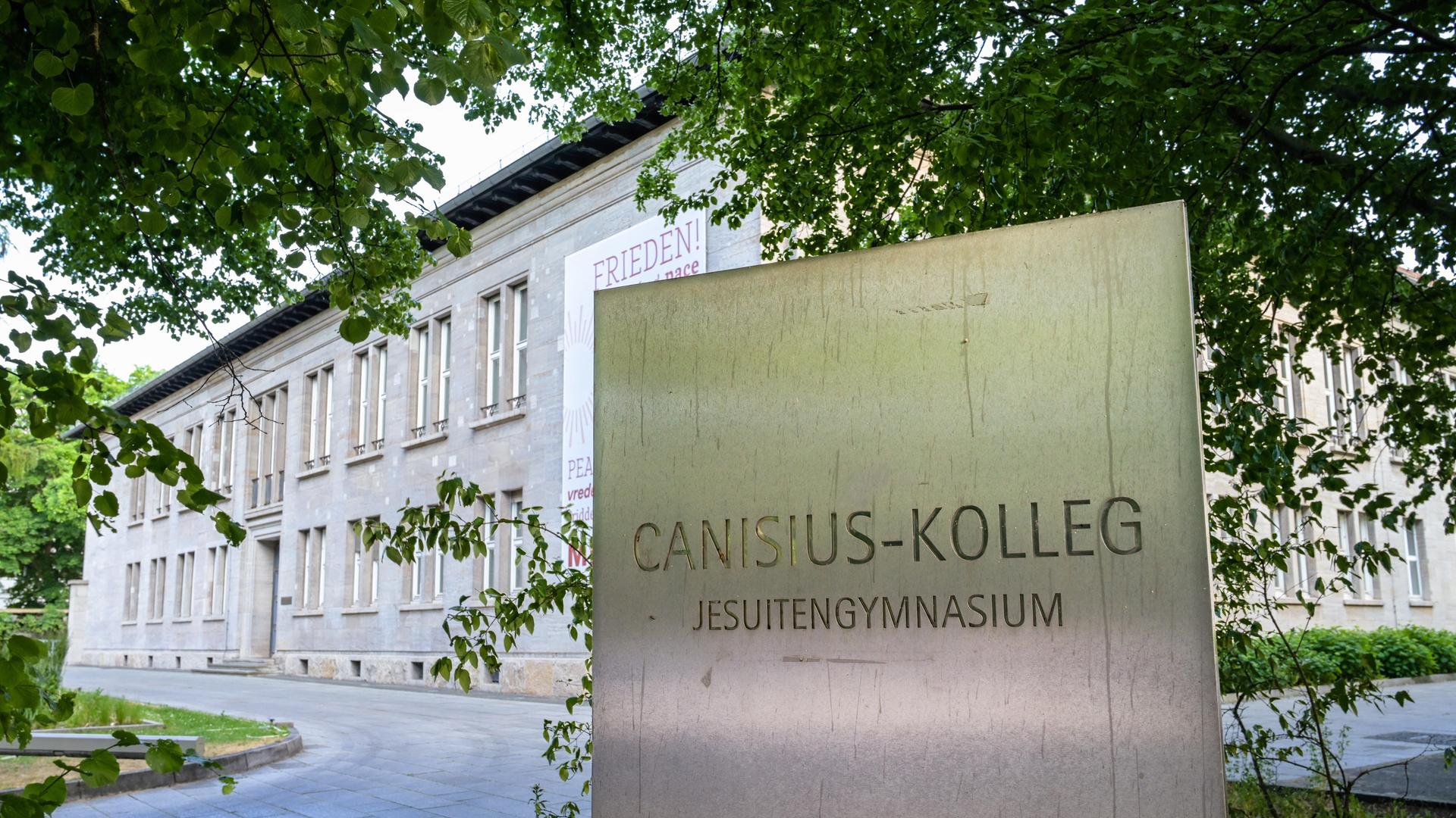 Ein Schild mit der Aufschrift "Canisius Kolleg, Jesuitengymnasium" vor dem Schulgebäude in Berlin