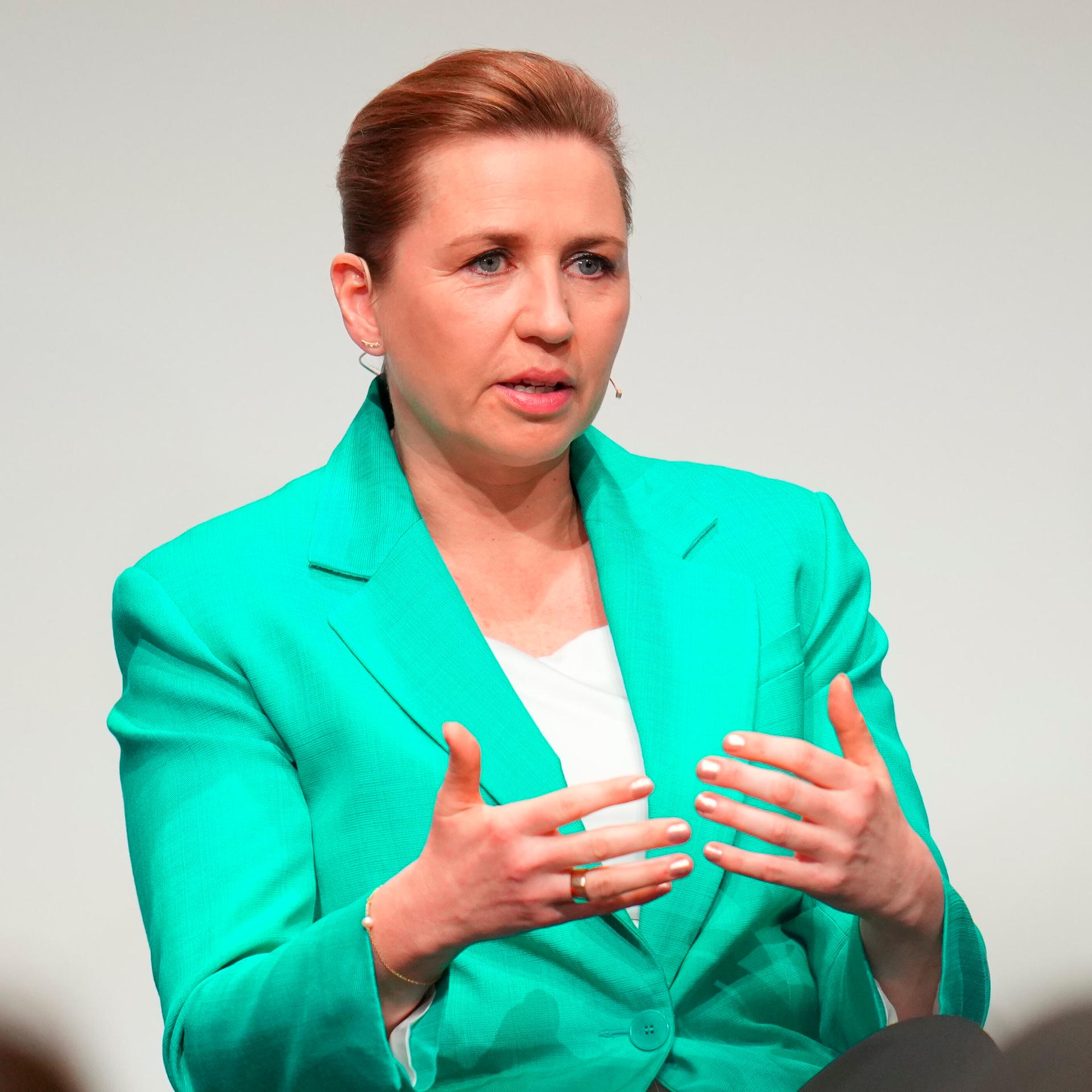 Dänemarks Ministerpräsidentin Mette Frederiksen spricht und gestikuliert mit beiden Händen.