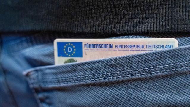 Ein deutscher Führerschein ragt aus einer Hosentasche.