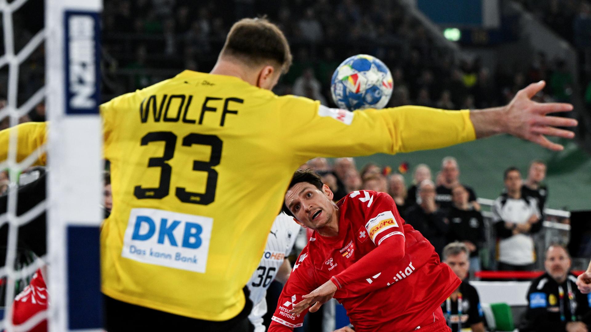Deutschlands Torwart Andreas Wolff versucht den Wurf von Nicolas Raemy aus der Schweiz abzuwehren. Deutschlands Torwart Andreas Wolff versucht den Wurf von Nicolas Raemy aus der Schweiz abzuwehren.