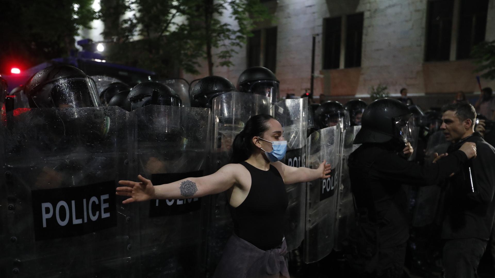 Demonstration in Tiflis: Eine Frau steht vor einer Polizeikette.