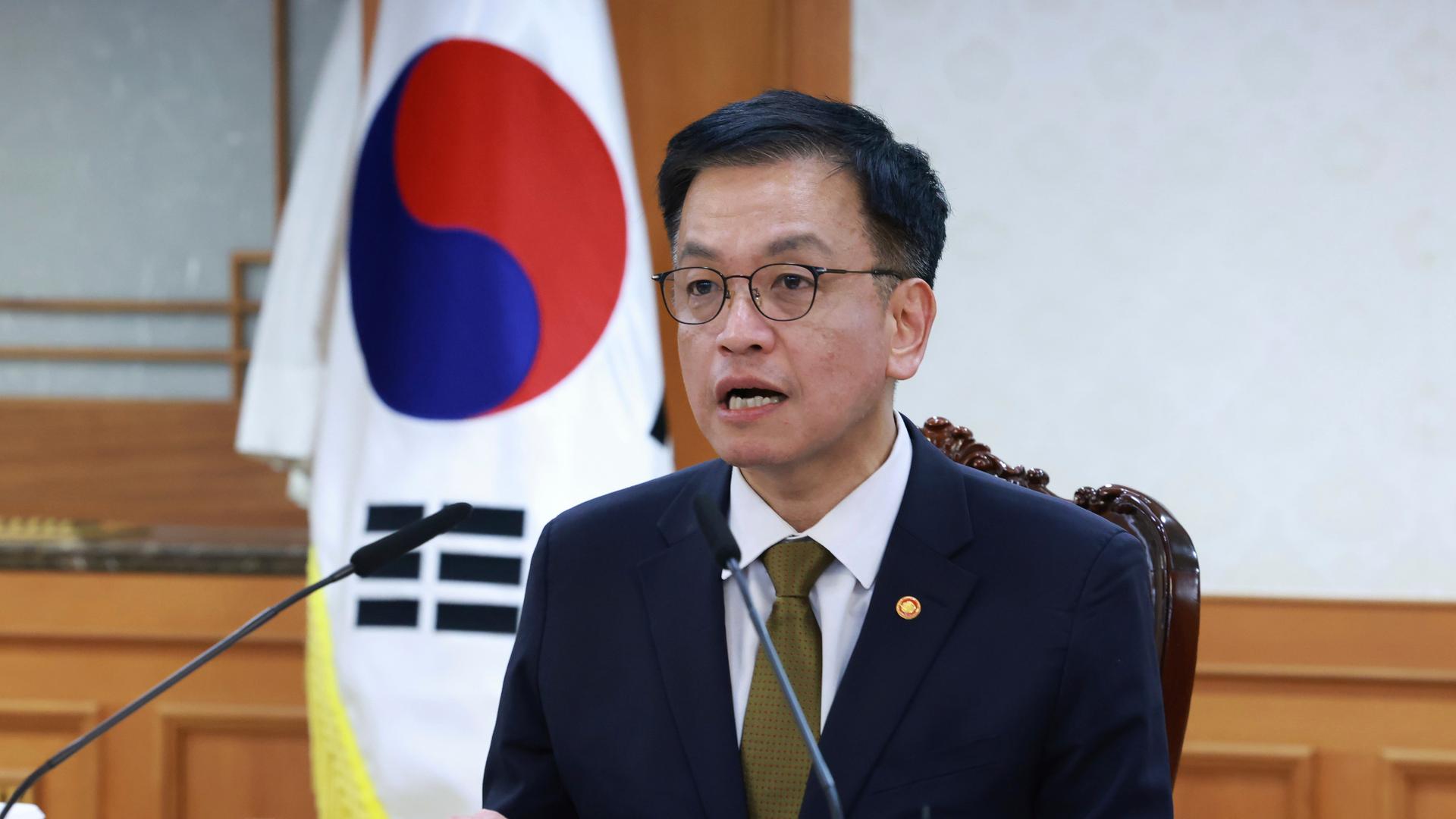 Das Bild zeigt ein Portrait des koreanischen Übergangspräsidenten Choi Sang-mok vor der Landesflagge. 