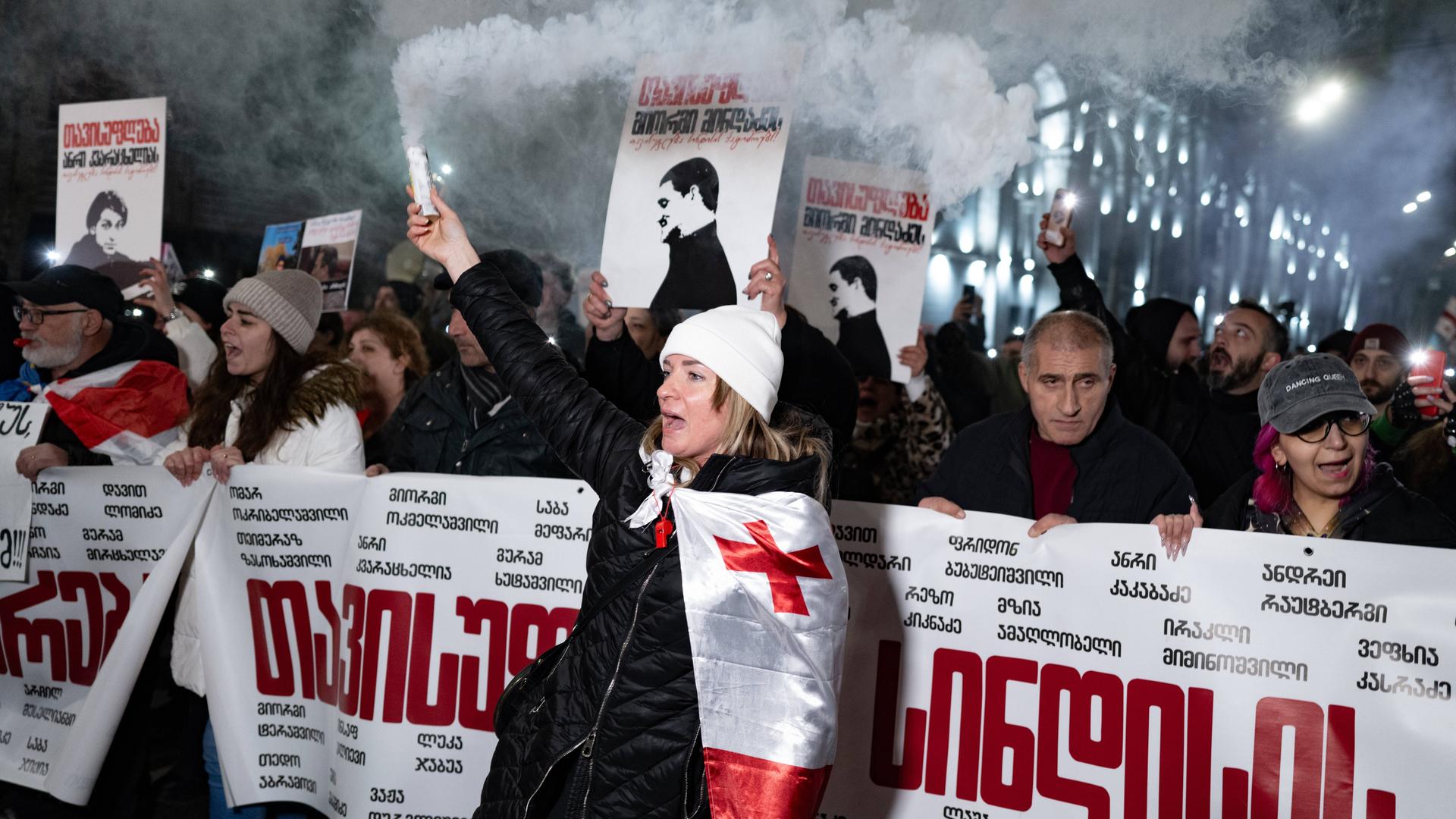 Demonstranten in Tiflis in Georgien halten Banner hoch