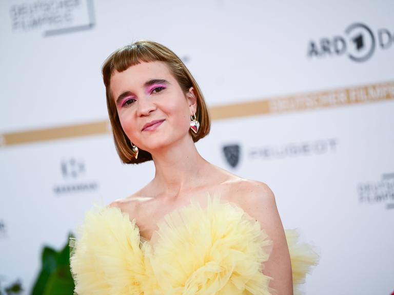 Caroline Wahl, Autorin, bei der Verleihung des Deutschen Filmpreises am Berliner Palais am Funkturm. Sie trägt ein gelbes schulterfreies Kleid. Caroline Wahl, Autorin, bei der Verleihung des Deutschen Filmpreises am Berliner Palais am Funkturm. Sie trägt ein gelbes schulterfreies Kleid.