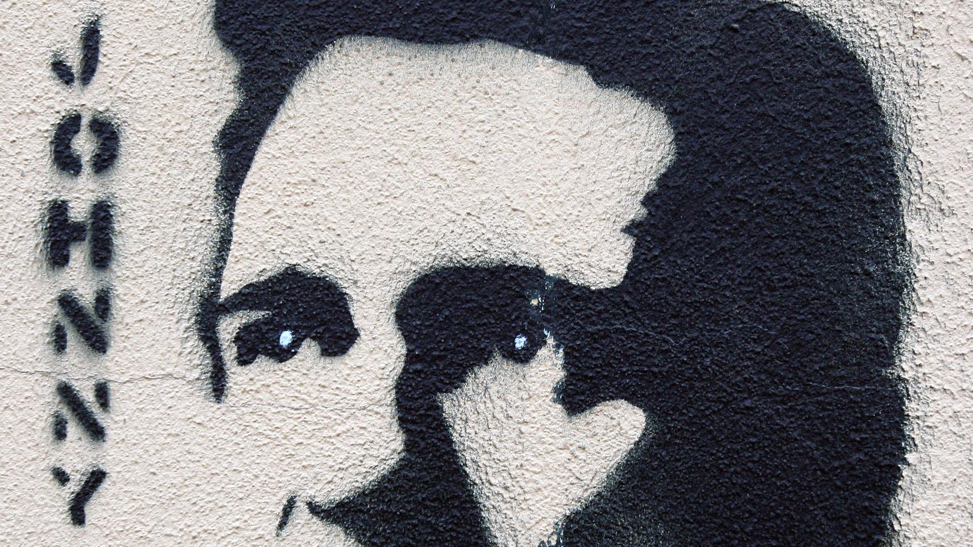 Ein Graffiti mit dem Abbild von Johnny Cash an einer Häuserwand in Berlin. Links steht "Johnny".