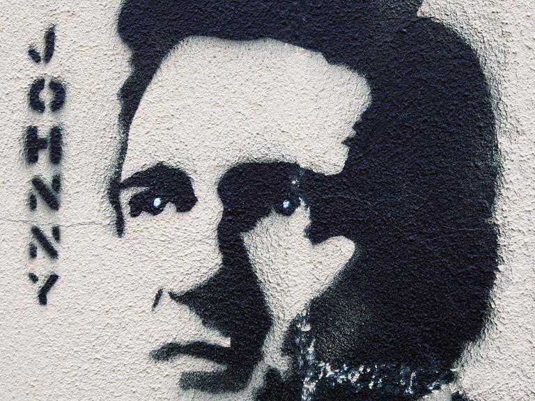 Ein Graffiti mit dem Abbild von Johnny Cash an einer Häuserwand in Berlin. Links steht "Johnny".