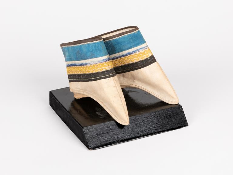 Geisha-Schuhe mit ungewöhnlicher Form, in die nur Füße hineinpassten, die an besonderen Stellen gebrochen wurden.