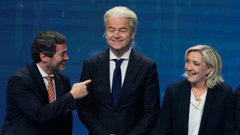 Andre Ventura, Geert Wilders und Marine Le Pen posieren für ein Pressefoto und scherzen miteinander.