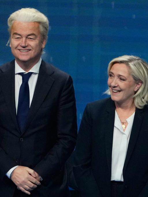 Andre Ventura, Geert Wilders und Marine Le Pen posieren für ein Pressefoto und scherzen miteinander.