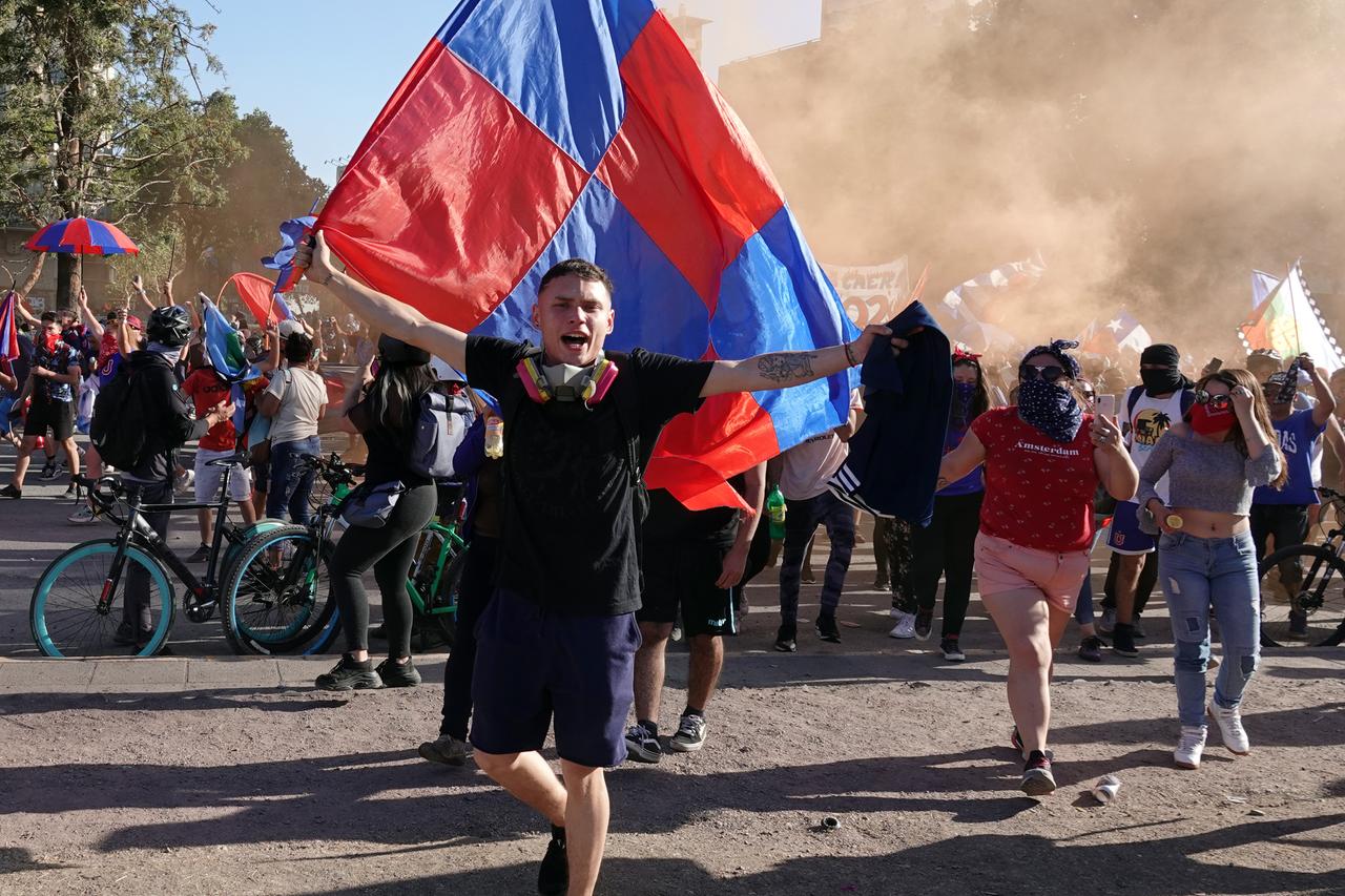 Proteste gegen die Regierung in Chile: Demonstrationsmenge, ein Mann schwenkt eine Flagge.