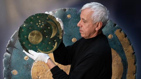 Im Landesmuseum in Halle/Saale hält der Restaurator Heiko Breuer die über 3.600 Jahre alte „Himmelsscheibe von Nebra“. 