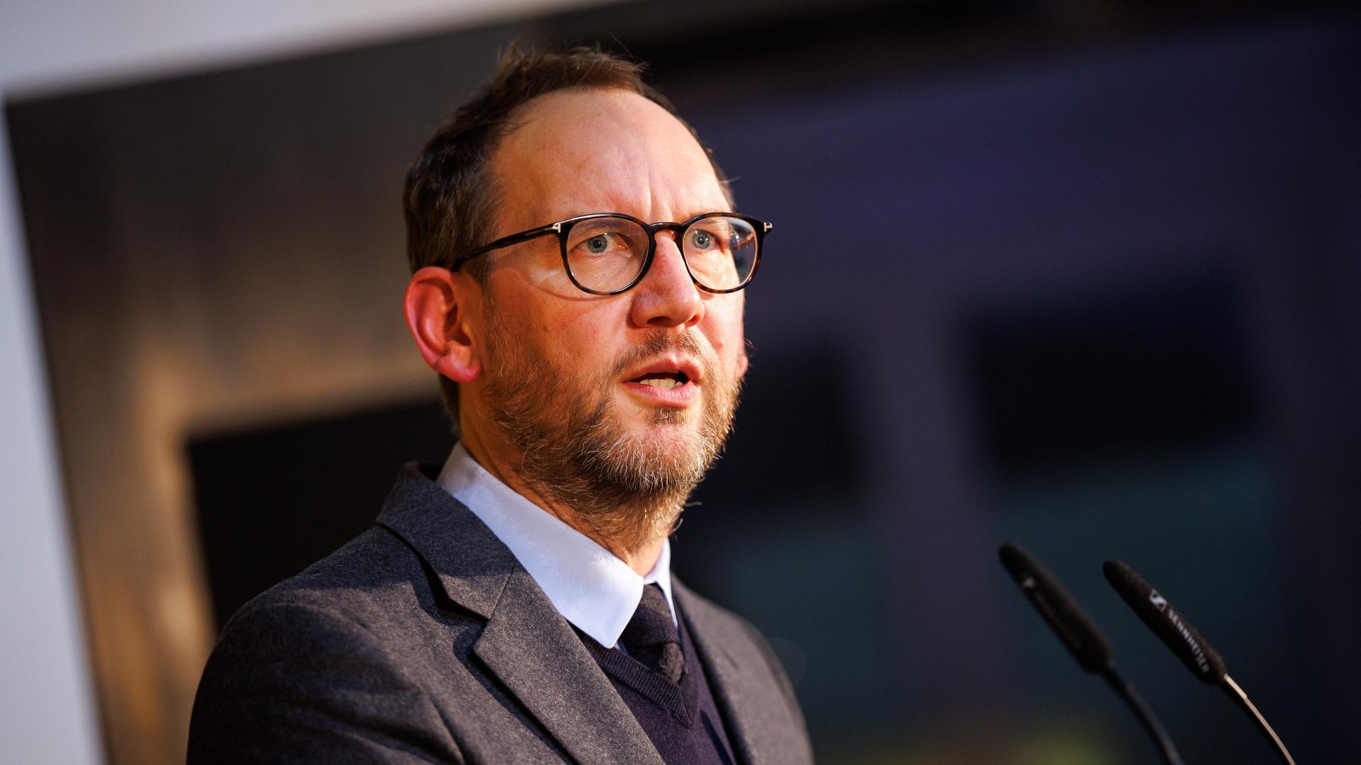 Michael Ebert, Chefredakteur des Magazins der Süddeutschen Zeitung bei einem Auftritt am Mikrophon. Er trägt Brille und hat einen Anzug an. 