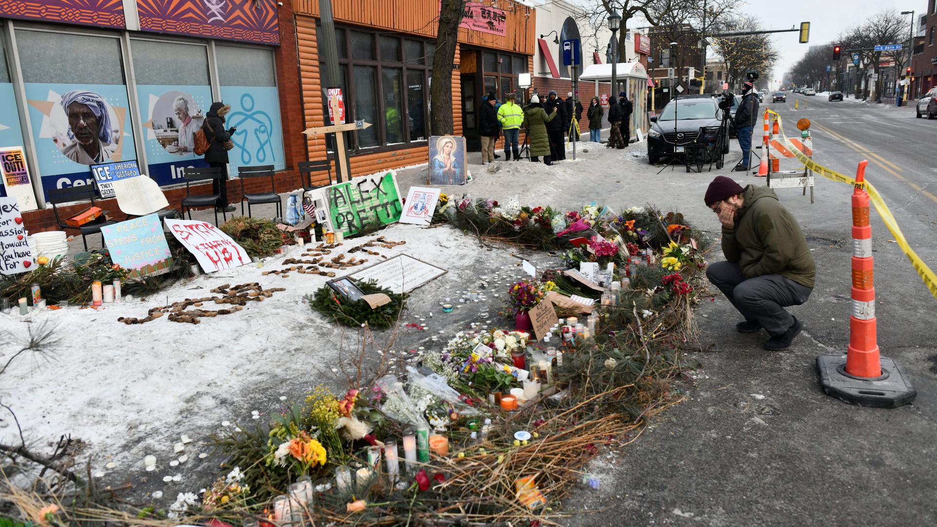25.01.2026 - Auf dem Boden vor einer Häuserzeile sind Blumen und Inschriften niedergelegt, ein Mann kniet davor, er hält eine Hand vors Gesicht. 25.01.2026 - Auf dem Boden vor einer Häuserzeile sind Blumen und Inschriften niedergelegt, ein Mann kniet davor, er hält eine Hand vors Gesicht.