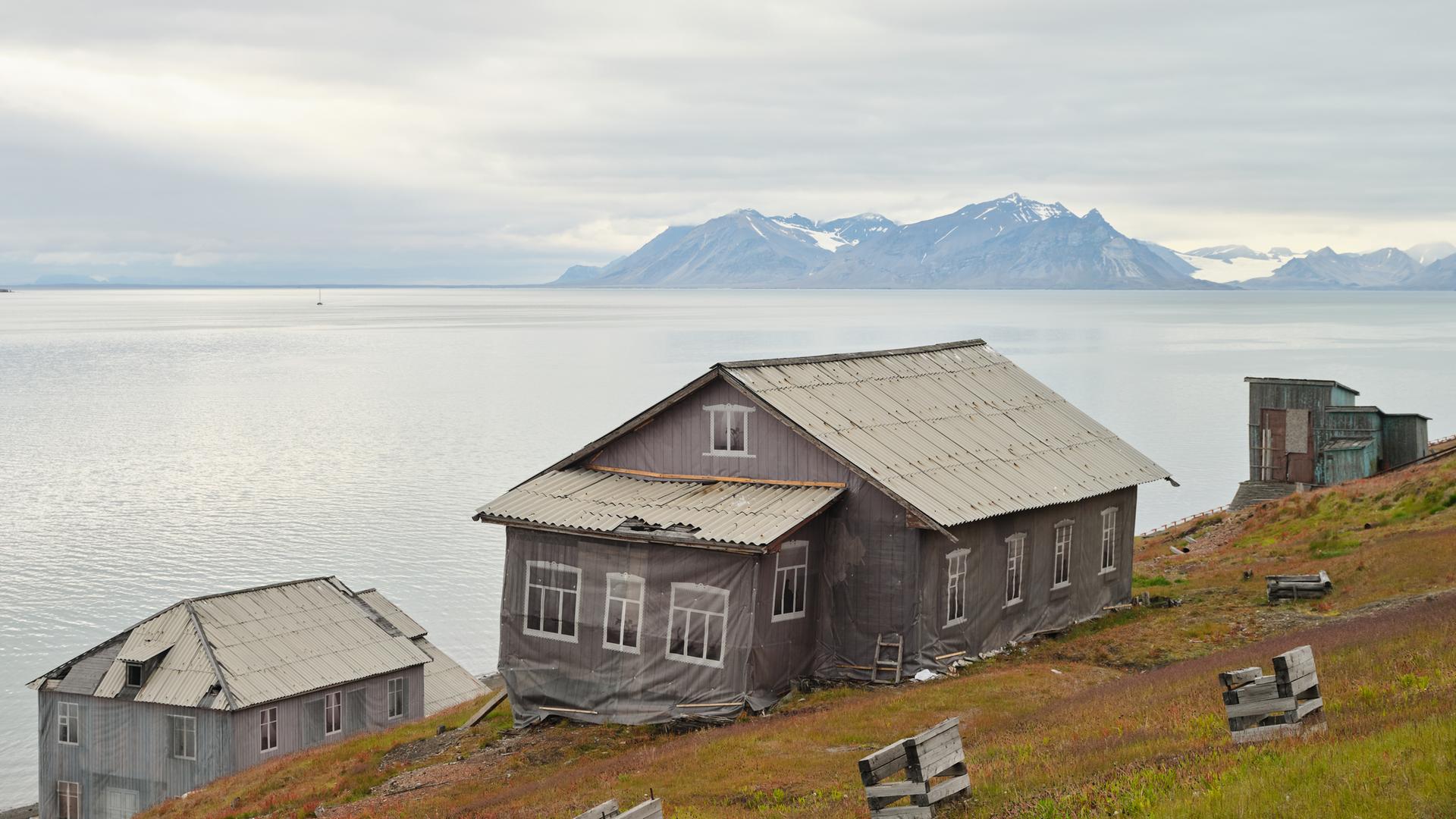 Häuser in Barentsburg, der russischen Siedlung auf Spitzbergen. Planen kaschieren den schleichenden Verfall. Im Hintergrund der Fjord und die Gletscher der Arktis.
Häuser in Barentsburg, der russischen Siedlung auf Spitzbergen. Planen kaschieren den schleichenden Verfall. Im Hintergrund der Fjord und die Gletscher der Arktis.