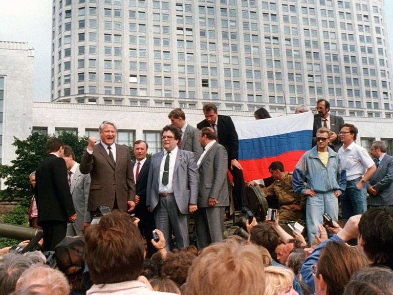 Der damalige russische Präsident Boris Jelzin steht 1991 in Moskau mit erhobener Faust auf einem Panzer. Um ihn herum sehr viele Demonstranten. Der damalige russische Präsident Boris Jelzin steht 1991 in Moskau mit erhobener Faust auf einem Panzer. Um ihn herum sehr viele Demonstranten.