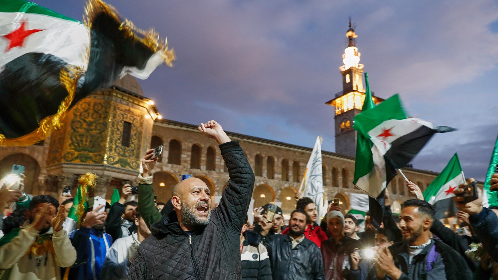 Damaskus: Syrer rufen Slogans und schwenken Fahnen vor der Umayyad-Moschee vor einem Gebet im Vorfeld der Feierlichkeiten zum ersten Jahrestag des Sturzes des Regimes von Assad. Damaskus: Syrer rufen Slogans und schwenken Fahnen vor der Umayyad-Moschee vor einem Gebet im Vorfeld der Feierlichkeiten zum ersten Jahrestag des Sturzes des Regimes von Assad.