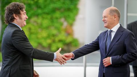 Scholz und Milei begrüßen sich mit Handschlag.
