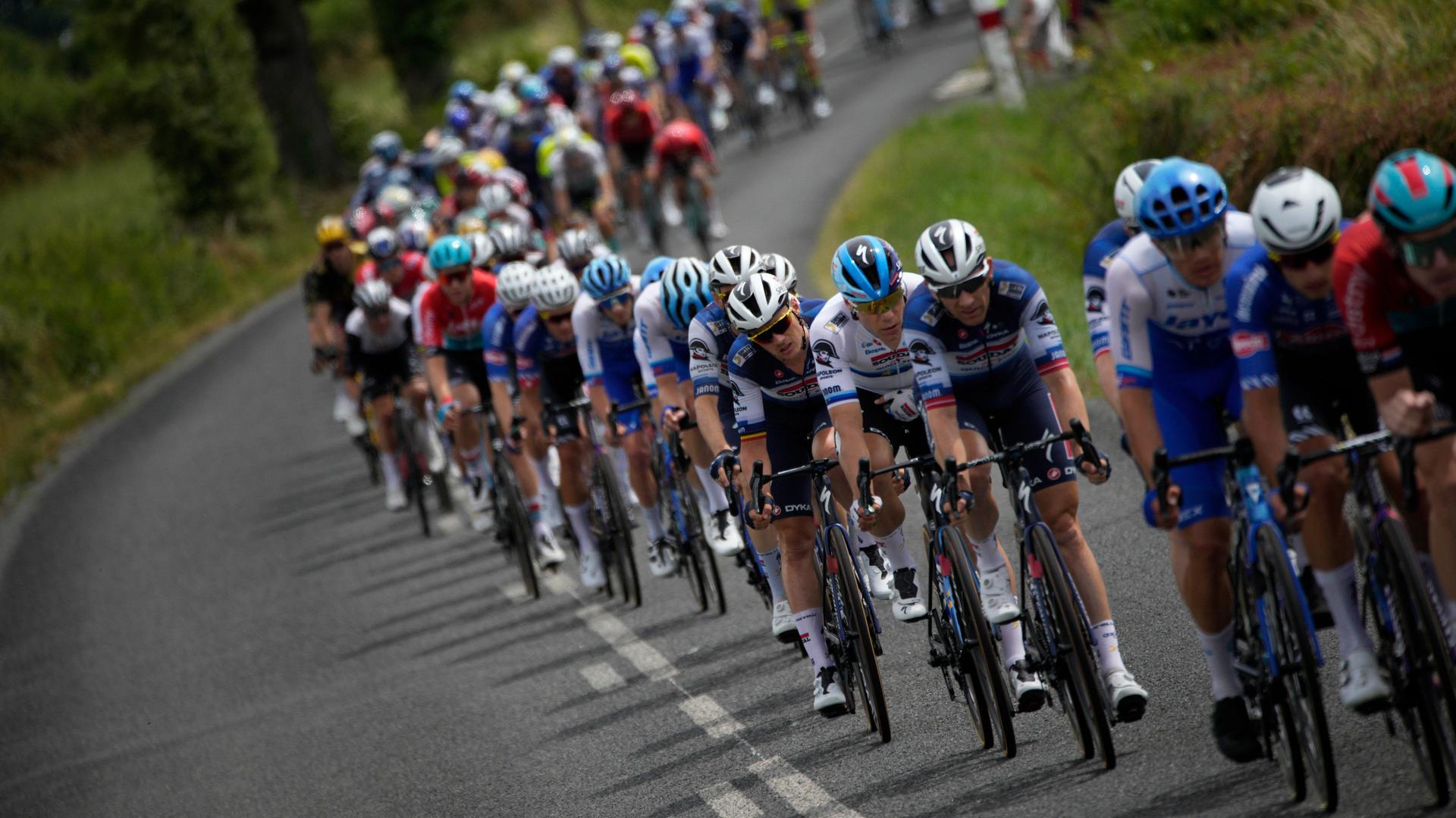 Das Peloton fährt über eine von Grün gesäumte Straße, Momentaufnahme von der 11. Etappe der Tour de France am 12.07.2023 Das Peloton fährt über eine von Grün gesäumte Straße, Momentaufnahme von der 11. Etappe der Tour de France am 12.07.2023