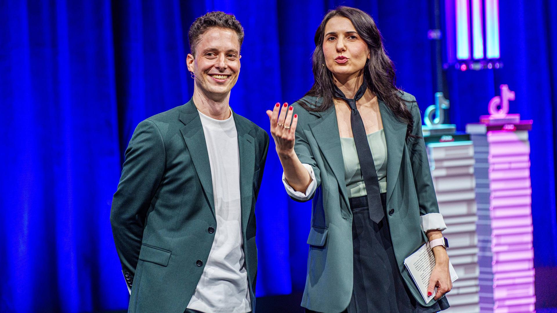 Matthias Renger und Iris Gavric moderieren auf einer Bühne der Frankfurter Buchmesse die Verleihung des TikTok Book Awards. Matthias Renger und Iris Gavric moderieren auf einer Bühne der Frankfurter Buchmesse die Verleihung des TikTok Book Awards.