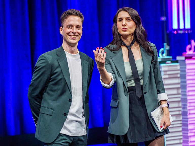 Matthias Renger und Iris Gavric moderieren auf einer Bühne der Frankfurter Buchmesse die Verleihung des TikTok Book Awards.