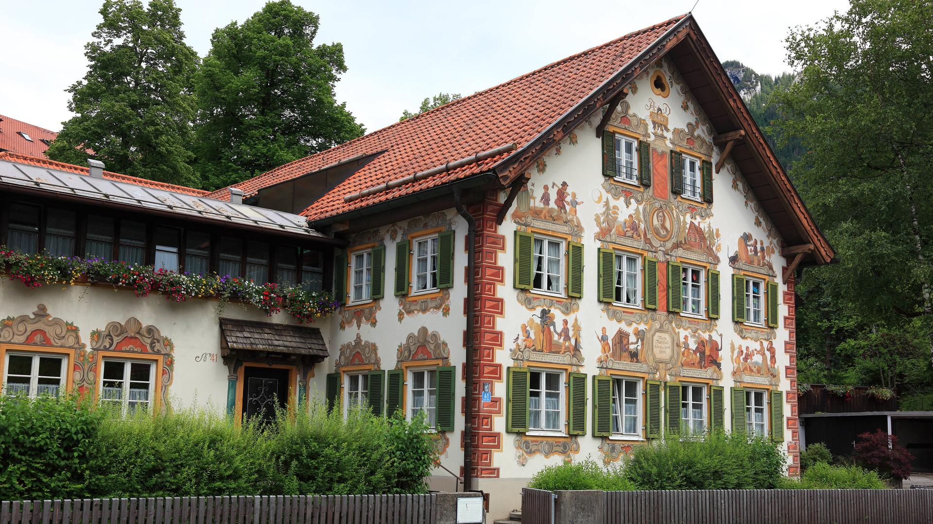 Außenansicht des Kinderheims in Oberammergau, das mit reichen Fassadenmalereien verziert ist.