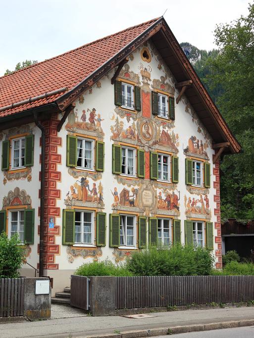 Außenansicht des Kinderheims in Oberammergau, das mit reichen Fassadenmalereien verziert ist.