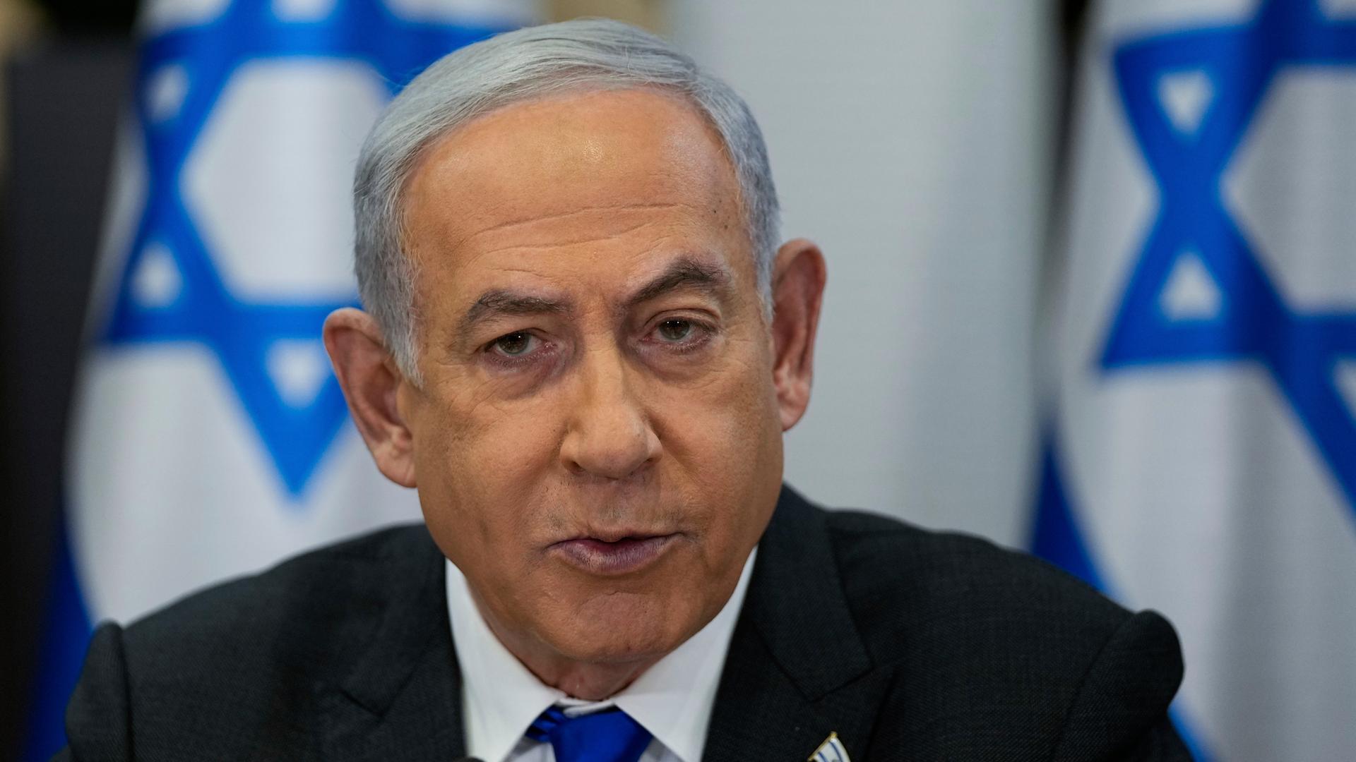 Benjamin Netanjahu, Ministerpräsident von Israel. Im Hintergrund sind Flaggen seines Landes zu sehen.