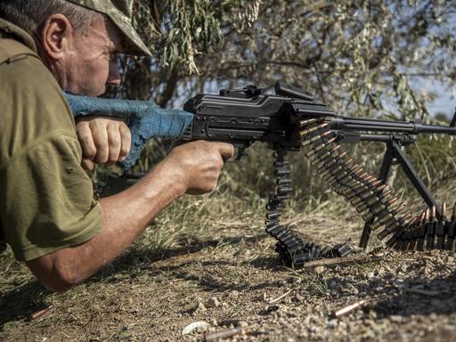 Ein ukrainischer Soldat bei einer Übung mit Maschinengewehr am Boden liegend. 