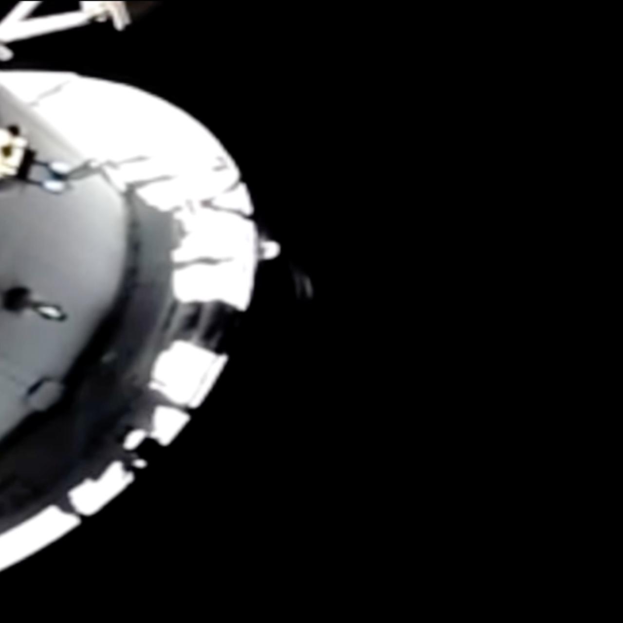 Der Mond, aufgenommen von einer Kamera außerhalb des Orion-Raumschiffs. Vor dem schwarzen Weltraum ragt ein Teil des Raumschiffs ins Bild.