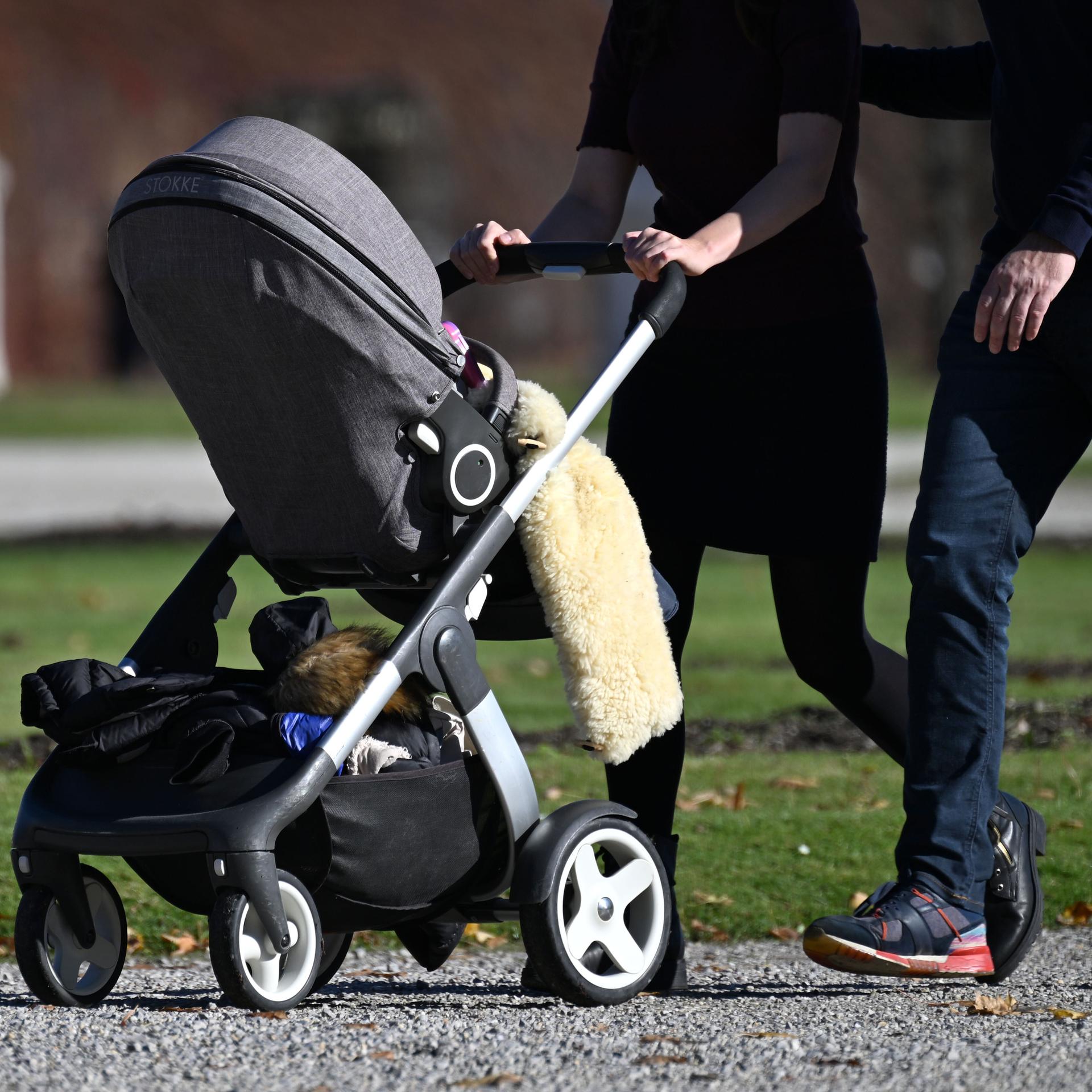  Eine Familie geht mit einem Kinderwagen spazieren