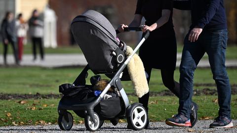  Eine Familie geht mit einem Kinderwagen spazieren