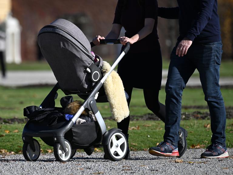 Eine Familie geht mit einem Kinderwagen spazieren. Eine Familie geht mit einem Kinderwagen spazieren.