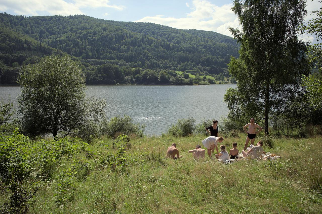 Menschen am See auf einer Sommerwiese.