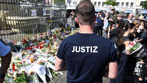Nach der Messerattacke in Mannheim liegen am Marktplatz in der unmittelbaren Nähe des Tatorts Blumen und Kerzen.