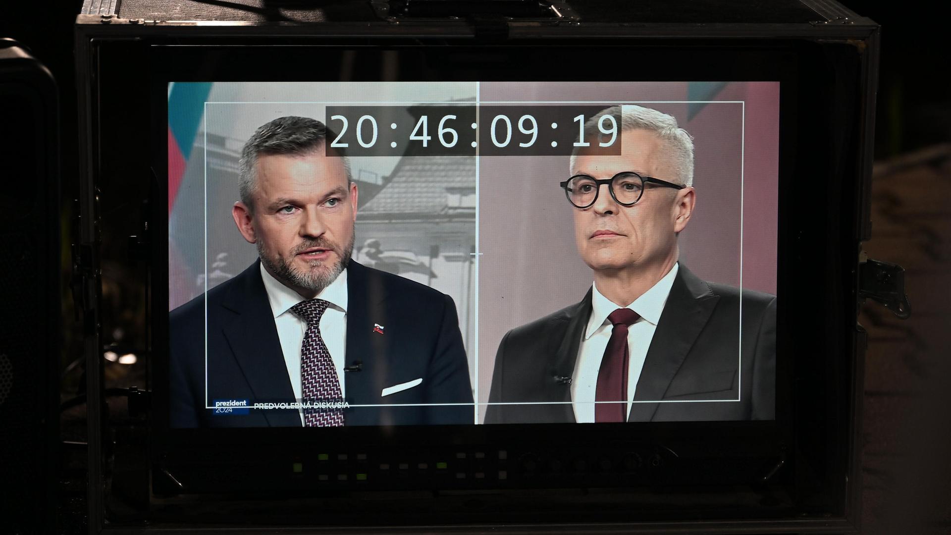 Die slowakischen Präsidentschaftskandidaten Peter Pellegrini und Ivan Korcok auf einem Monitor während einer Fernsehdebatte vor der Wahl bei TV Markiza, Bratislava, Slowakei, am 18. März 2024.
