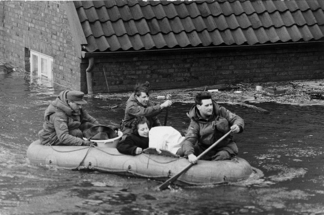 Sturmflut in Norddeutschland Februar 1962: Eine Frau wird mit einem Schlauchboot in Sicherheit gebracht.