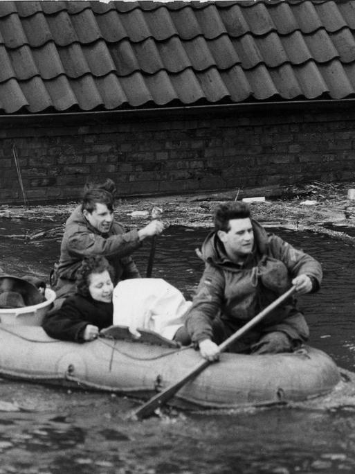 Sturmflut in Norddeutschland Februar 1962: Eine Frau wird mit einem Schlauchboot in Sicherheit gebracht.
