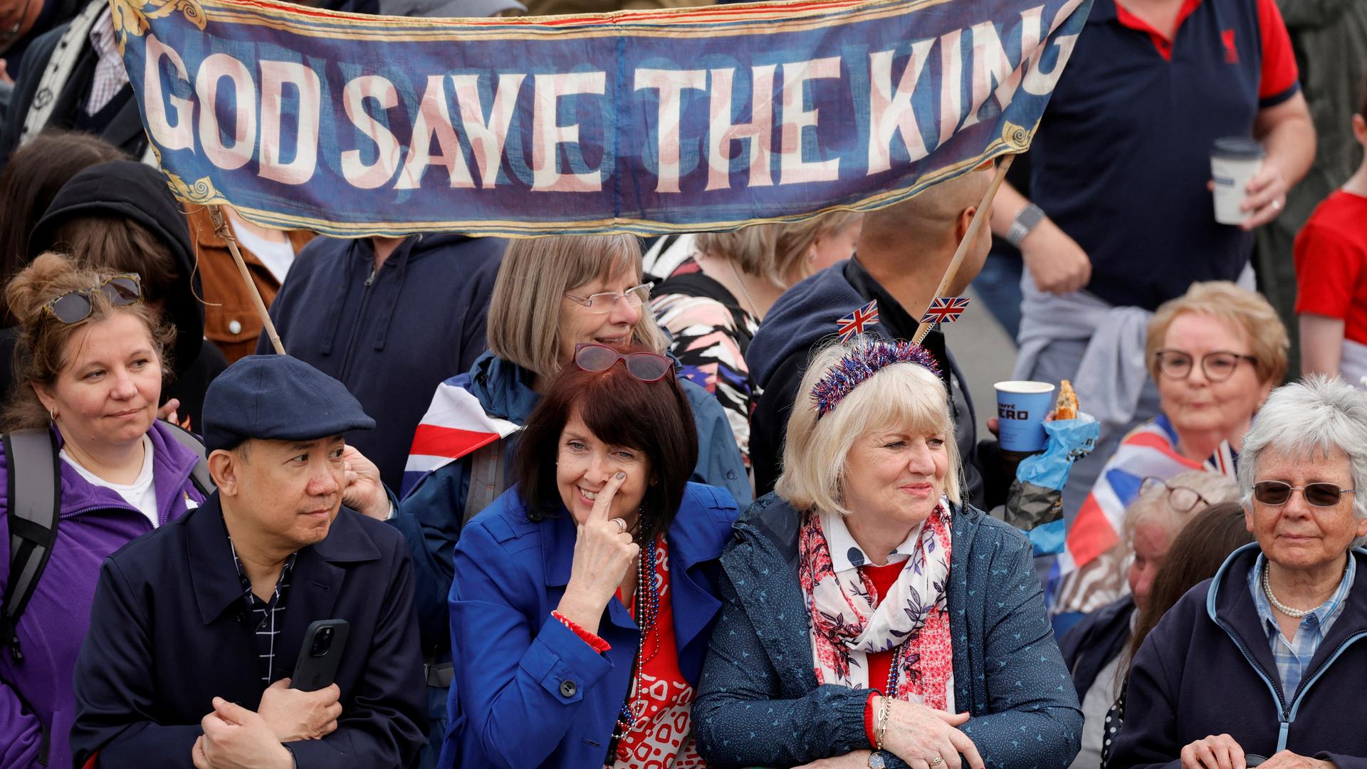 Schaulustige an der Prozessionsroute im Zentrum Londons. Auf einem Banner steht "God save the king", Gott schütze den König. Schaulustige an der Prozessionsroute im Zentrum Londons. Auf einem Banner steht "God save the king", Gott schütze den König.