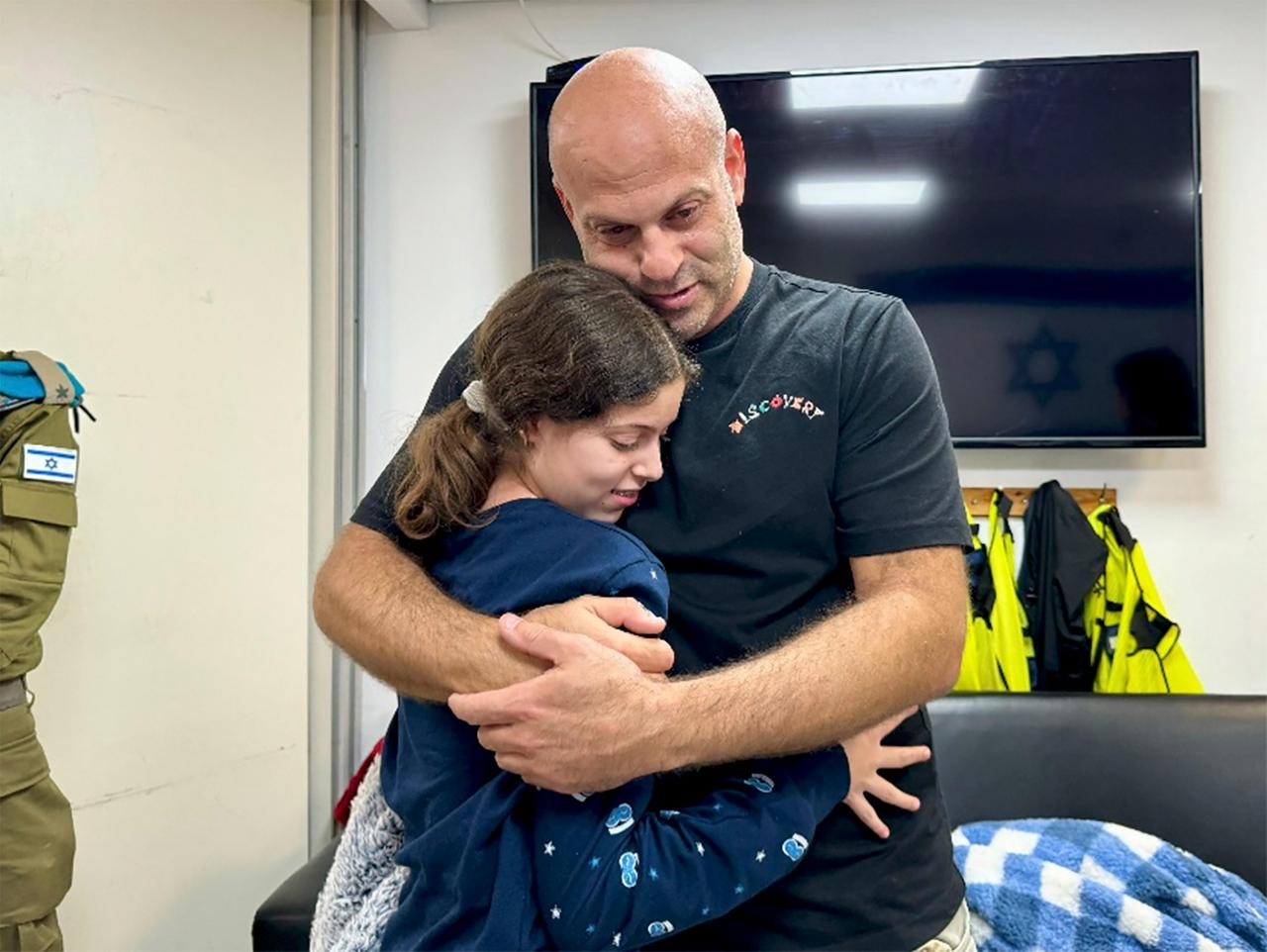 Das Foto der israelischen Armee zeigt Hila Rotem Shoshani, die von der Hamas als Geisel entführt worden war, nach ihrer Freilassung mit ihrem Onkel.