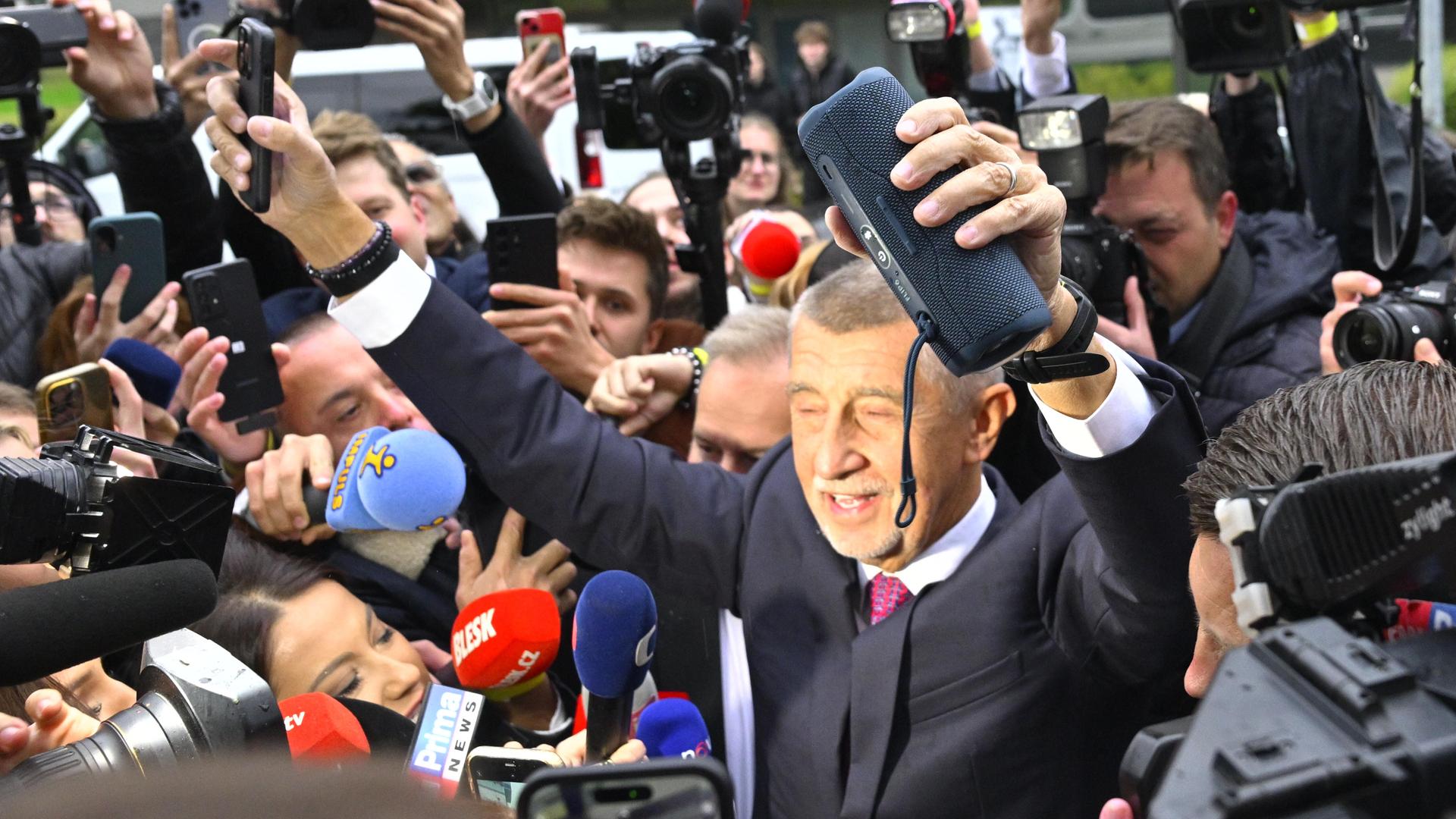 Das Bild zeigt den jubelnden Vorsitzenden der Partei ANO, Andrej Babis, umringt von Journalisten. 