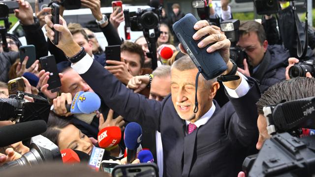 Das Bild zeigt den jubelnden Vorsitzenden der Partei ANO, Andrej Babis, umringt von Journalisten. 