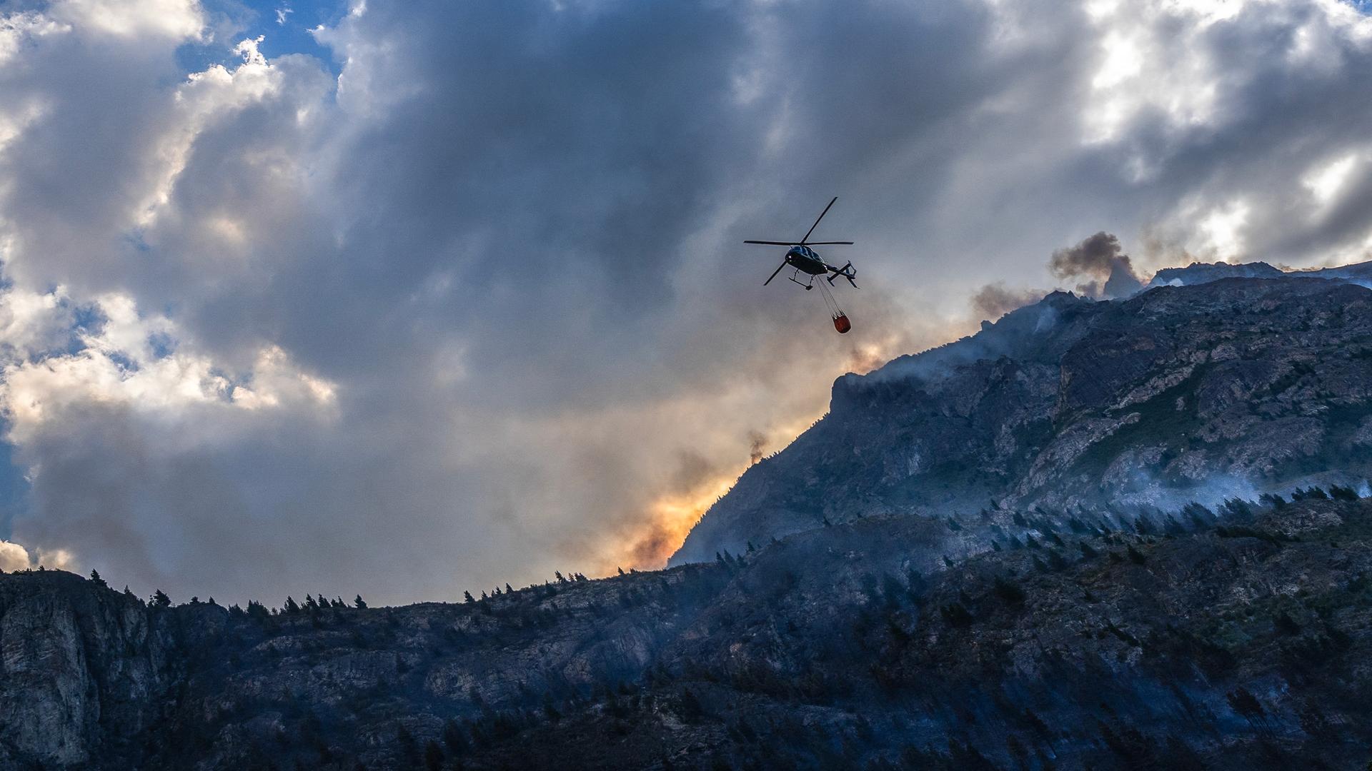 Ein Hubschrauber lässt Wasser ab, um einen Waldbrand in Argentinien zu löschen. 
