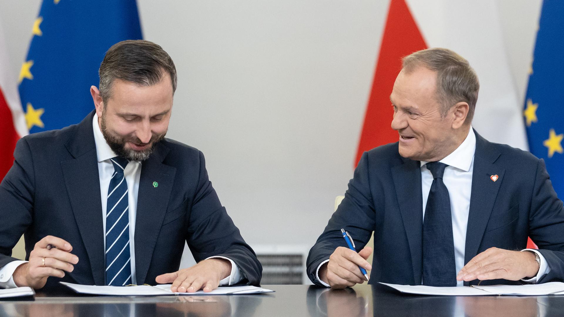 Wladyslaw Kosiniak-Kamysz und Donald Tusk unterschreiben den Koalitionsvertrag.