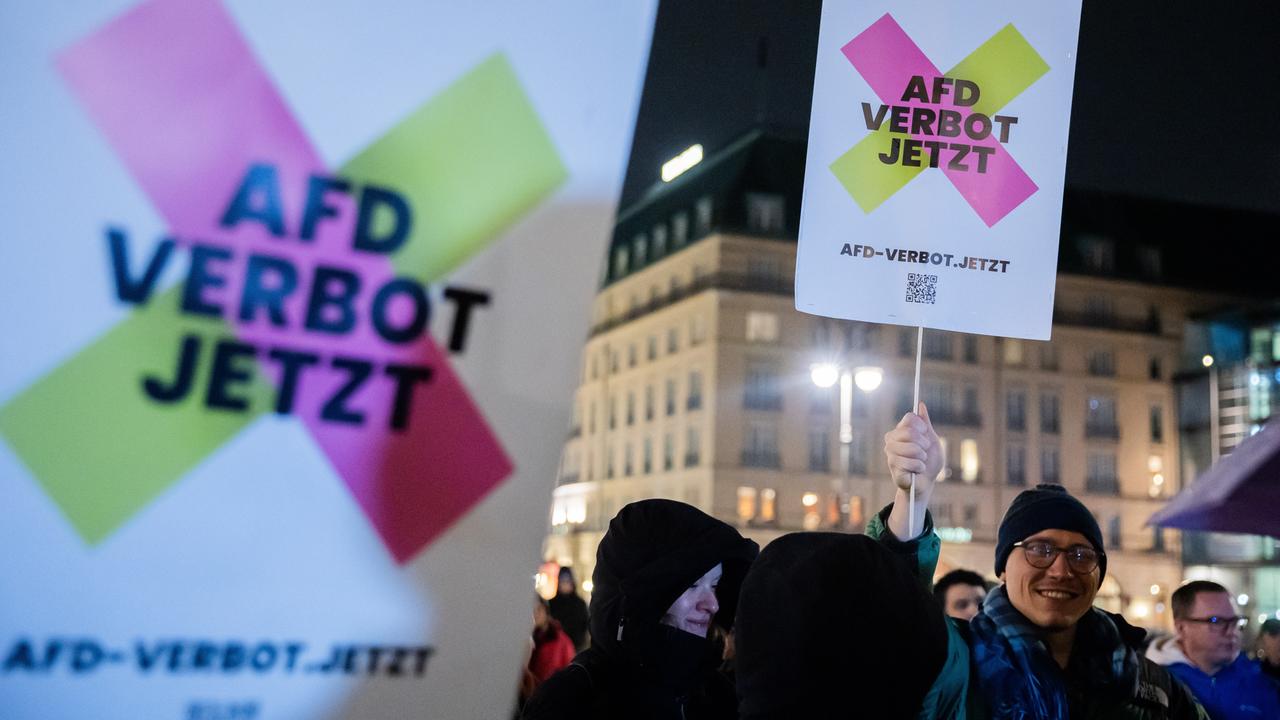 "AfD Verbot jetzt" steht bei einer Kundgebung gegen die Asylpolitik von CDU/CSU und der AfD am Brandenburger Tor auf Plakaten.
