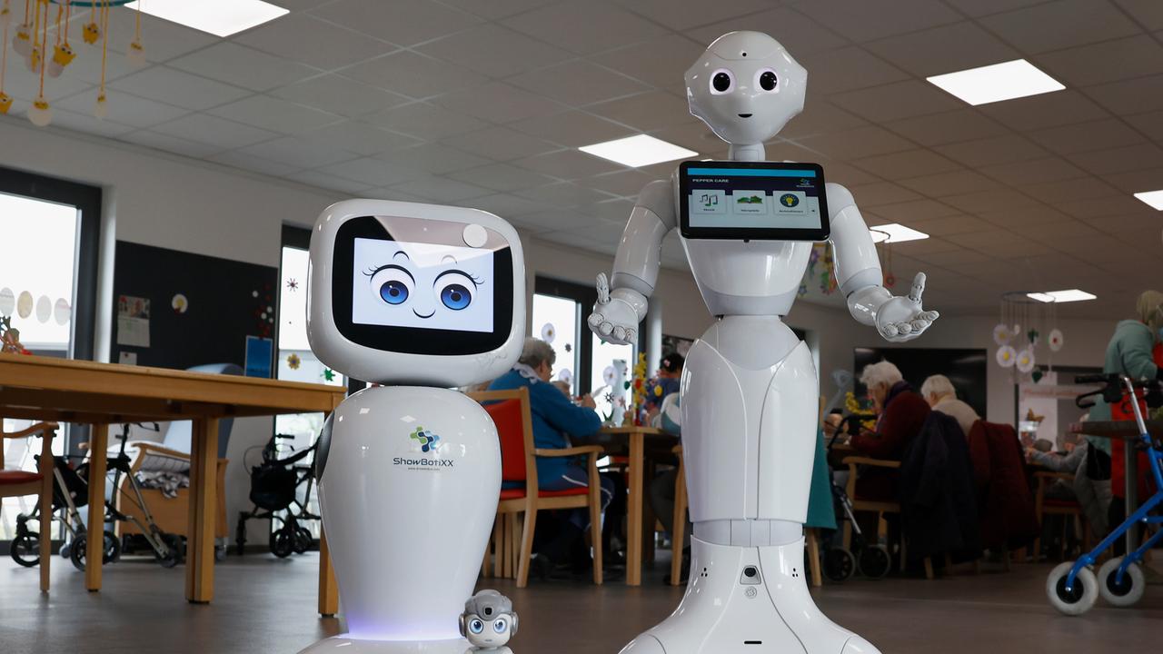 Weiß glänzende Pflegeroboter mit künstlichen Gesichtern der Firma BeckerRobotics in einem Pflegeheim