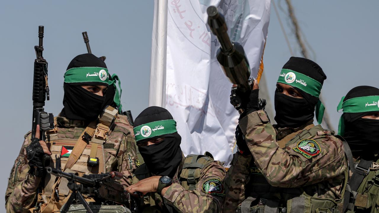 Mehrere Kämpfer der Hamas halten Waffen in die Höhe, ihre Gesichter sind vermummt.