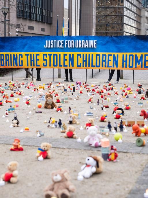 Eine Demonstration für von Russland entführte Kinder in Brüssel. Die US Nichtregierungsorganisation AVAAZ entzündet Kerzen neben Kuscheltieren.